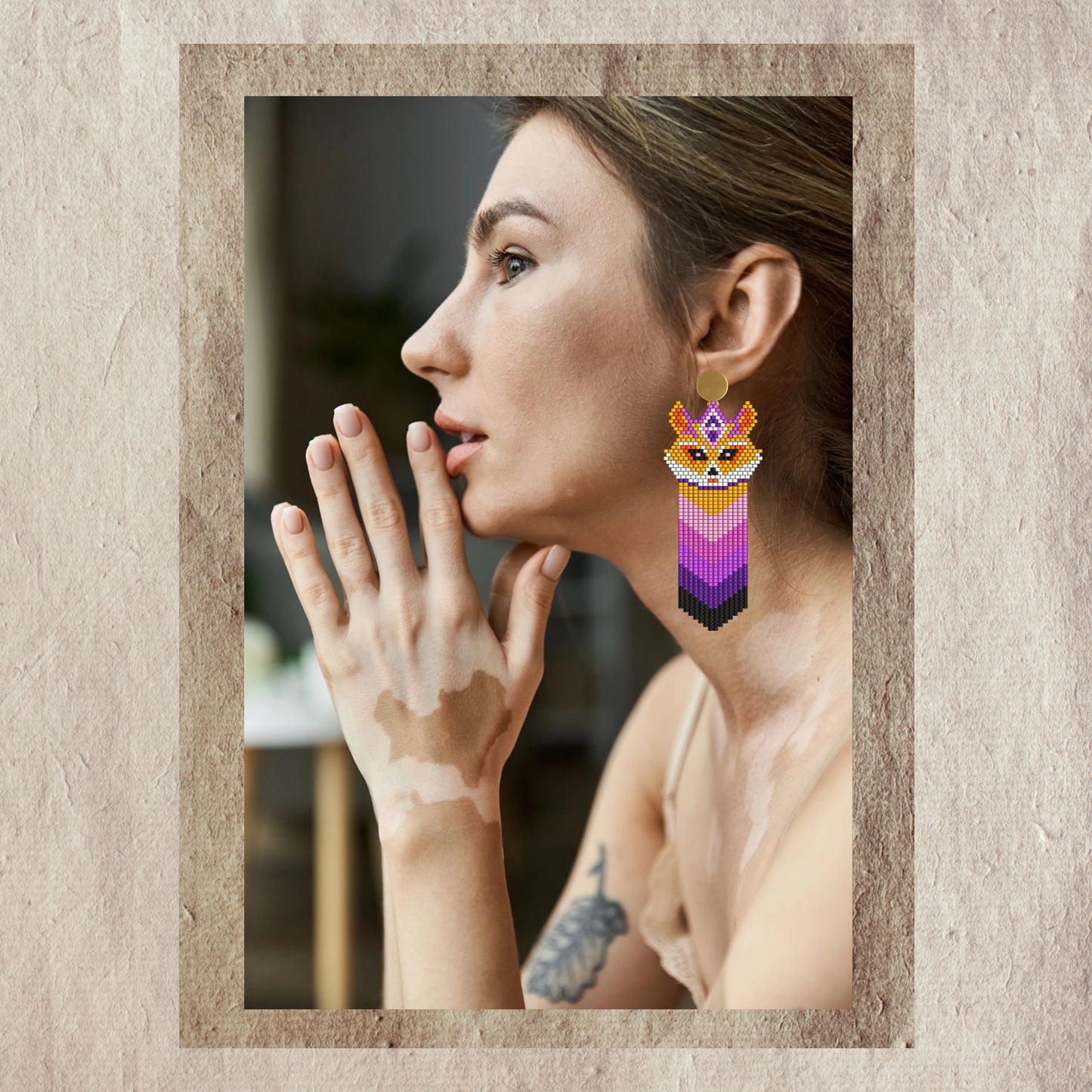 Woman wearing fox beaded earrings with a neutral background