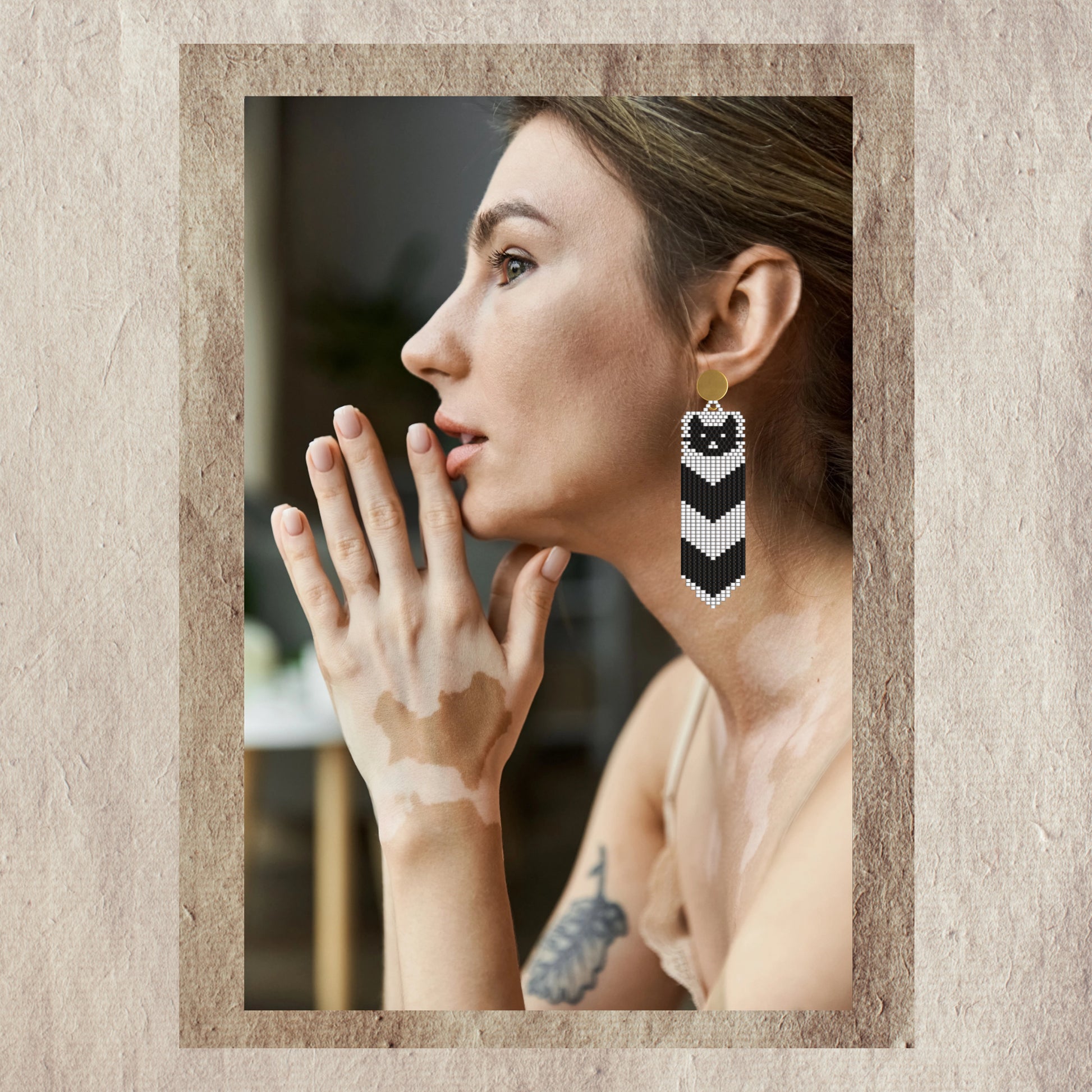 Woman wearing a cat Halloween  earring with a textured design, set against a neutral background.