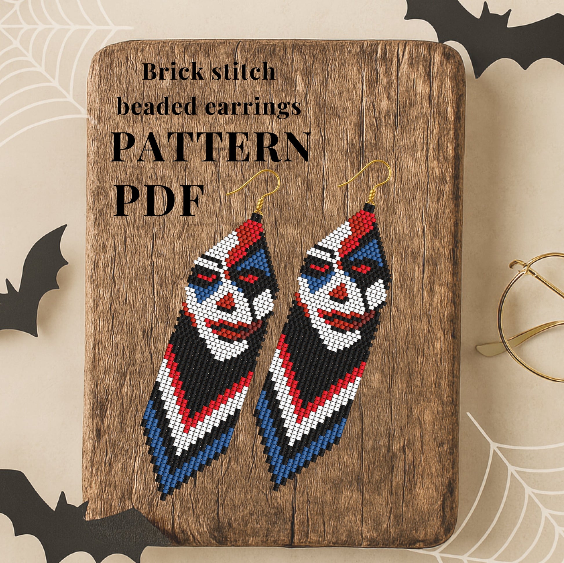 Brick stitch beaded earrings on a wooden board with Halloween-themed decorations.