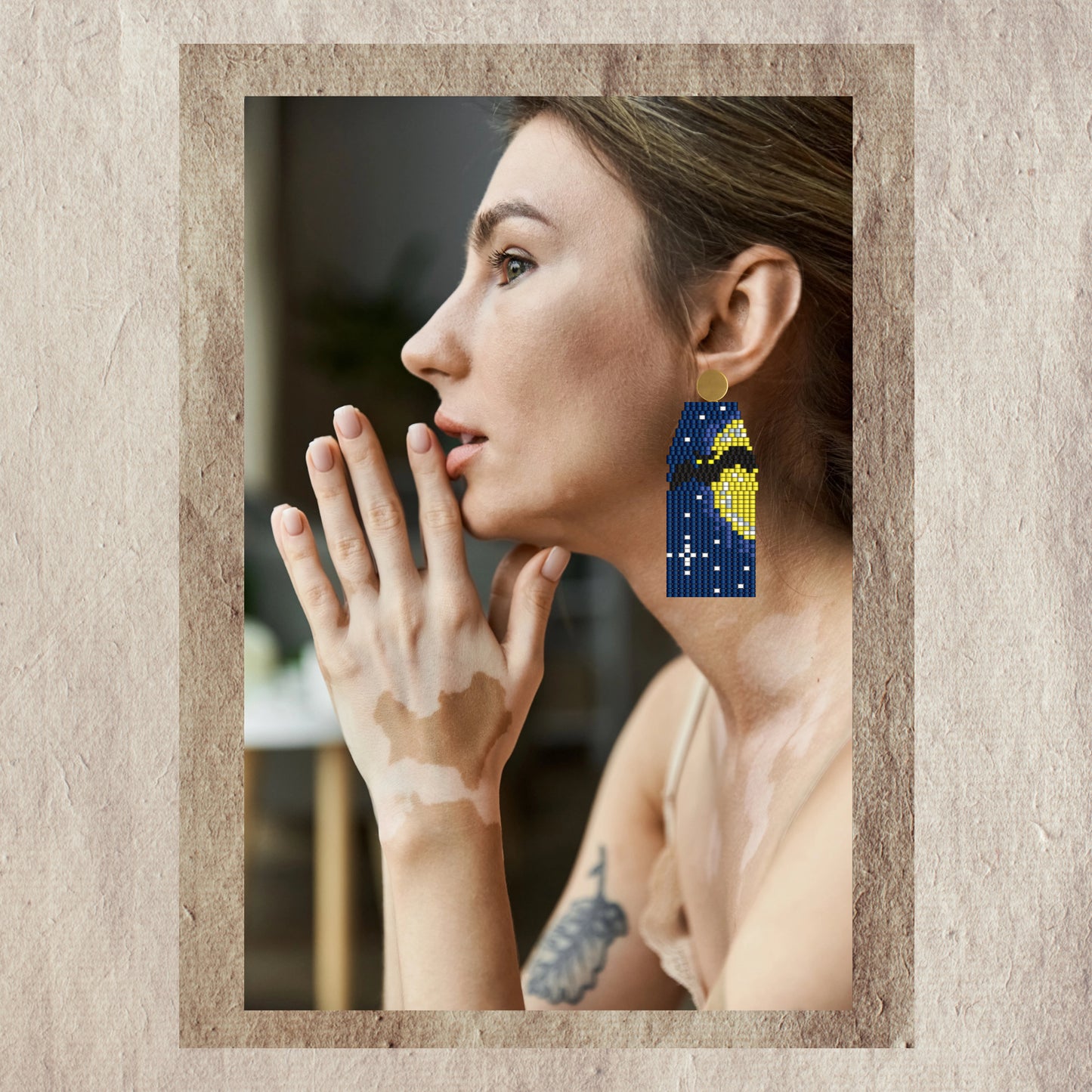 Woman wearing halloween bat  beaded earrings with a neutral background