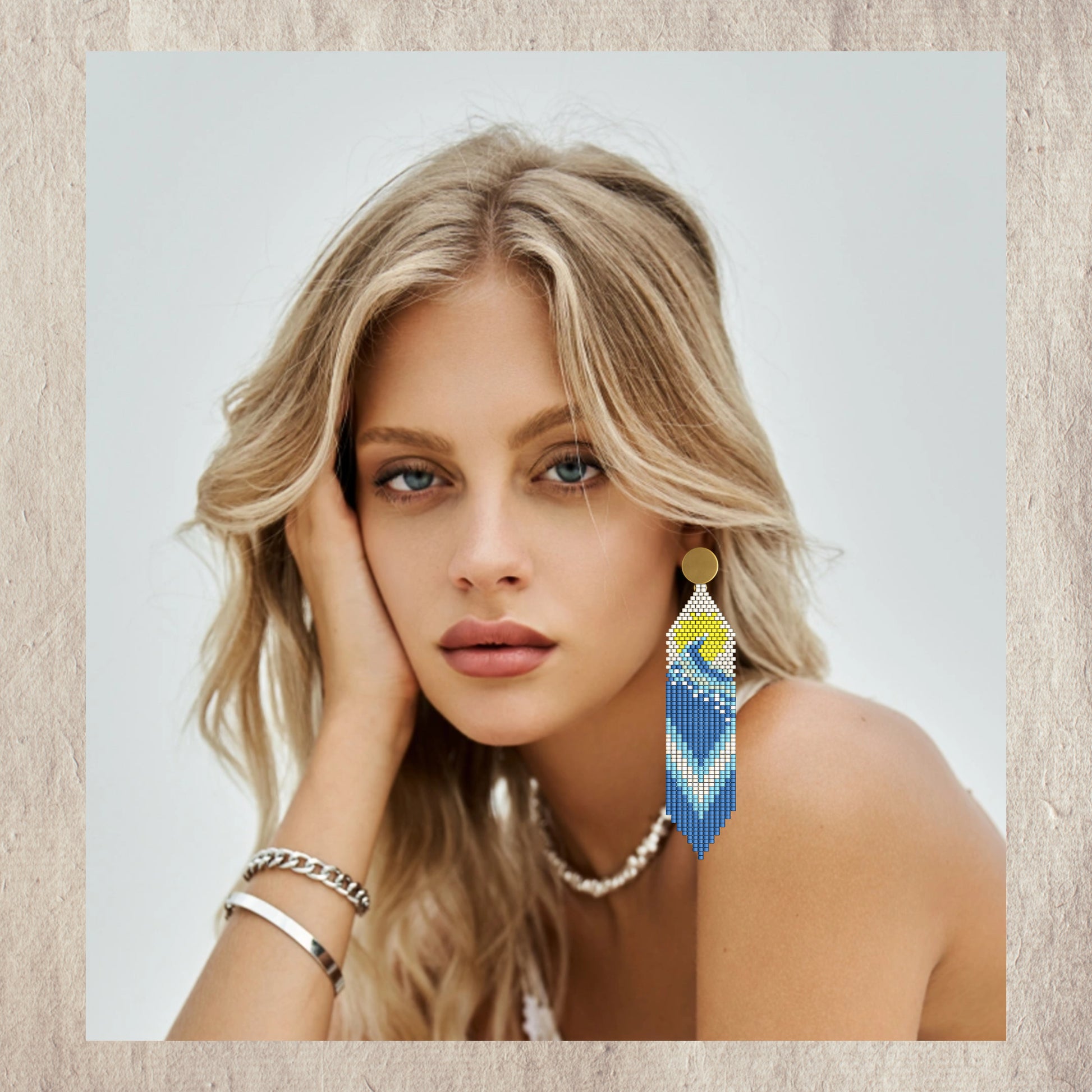 Woman wearing a pair of wave beaded earrings with a neutral background