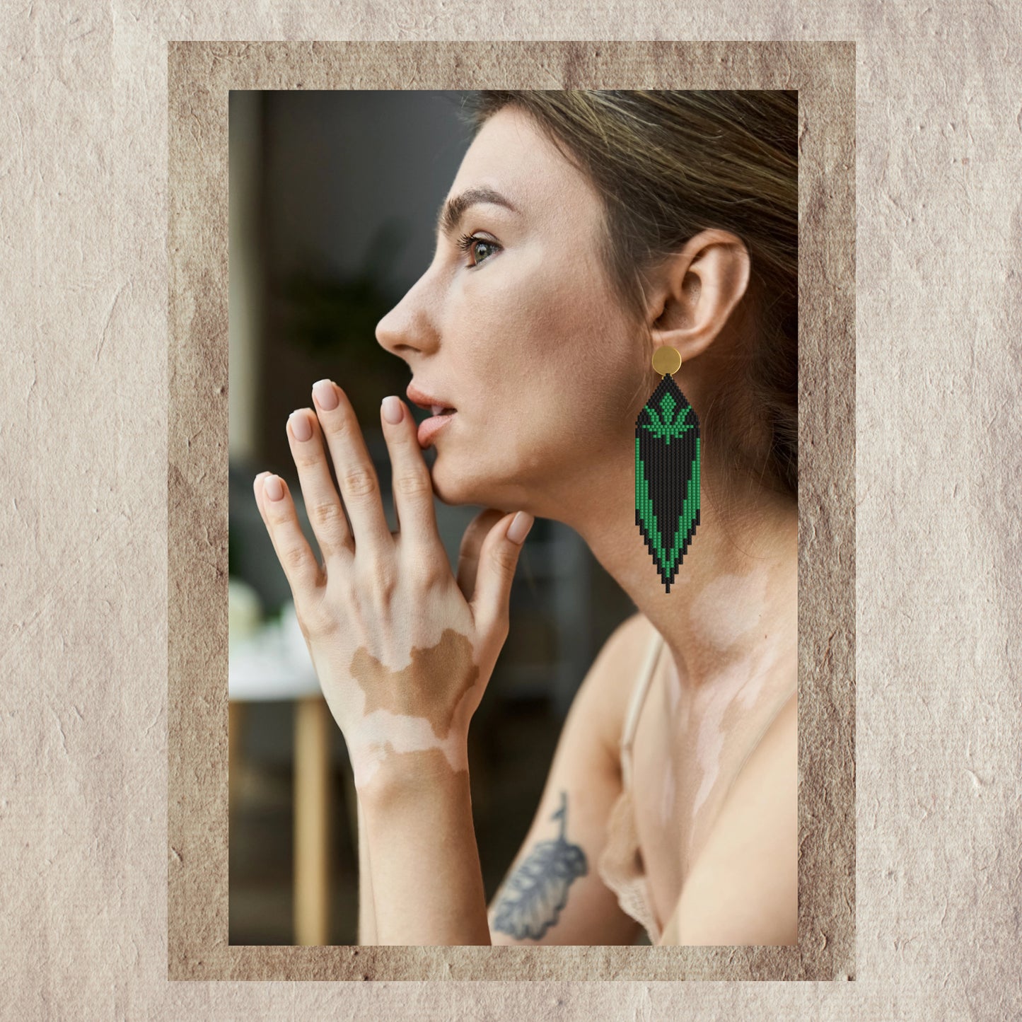 Woman wearing marijuana green earring with a textured beige border